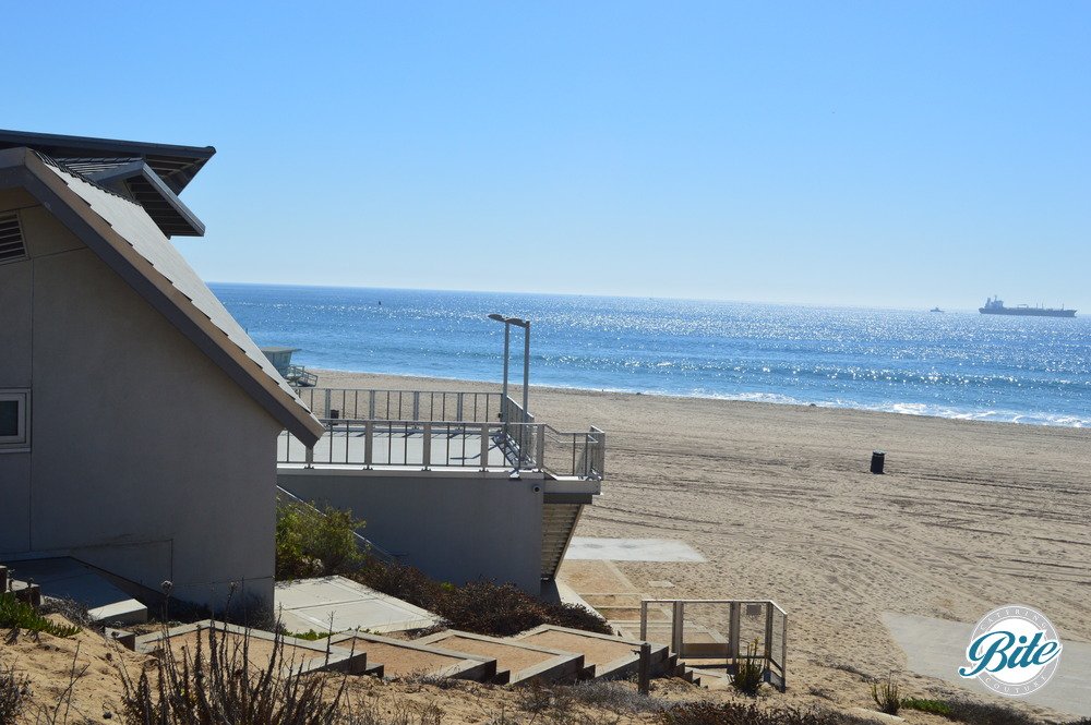 Photo of Dockweiler Beach Youth Center from the trail, showing the ocean view and balcony.