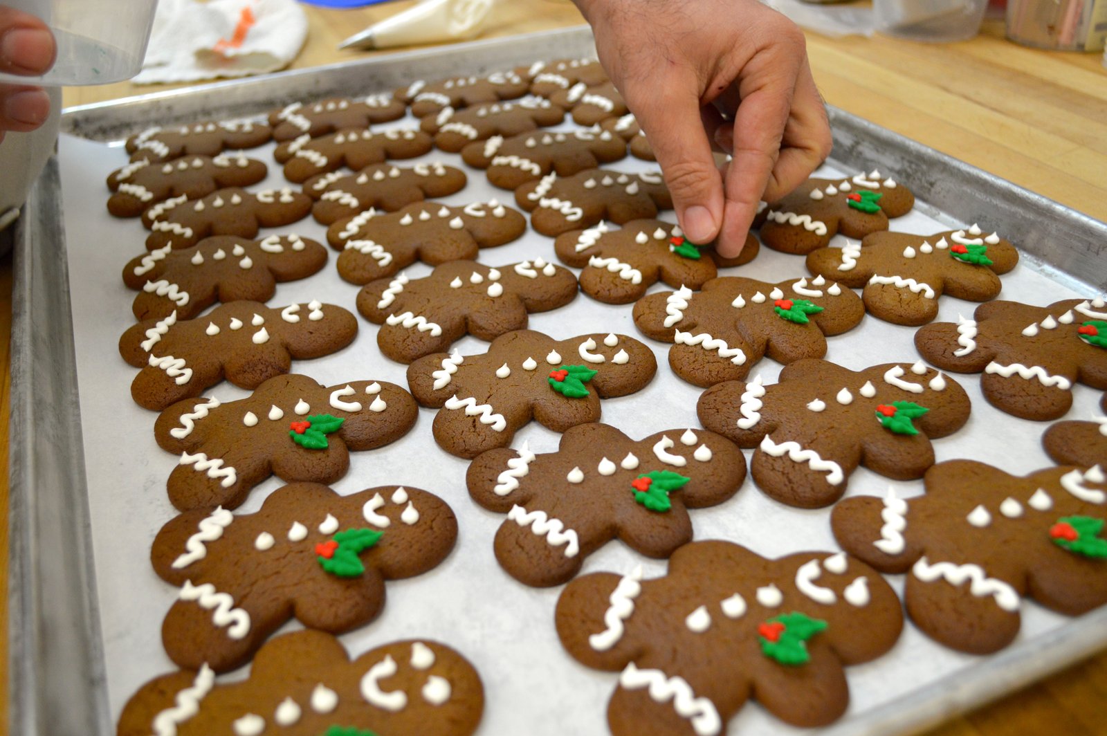 Our pastry chef putting the finishing touches on a holiday tradition - our adorable gingerbread men are ready to party!