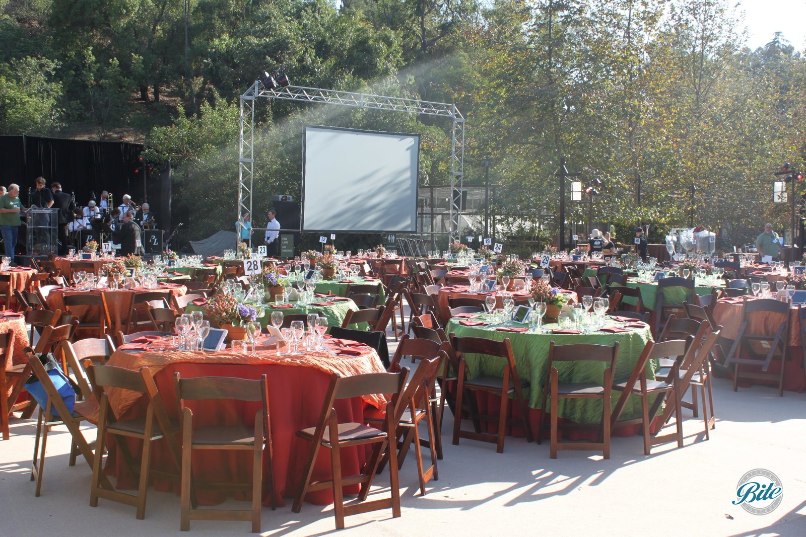 Tables and chairs set up in front of stage for outdoor fundraiser